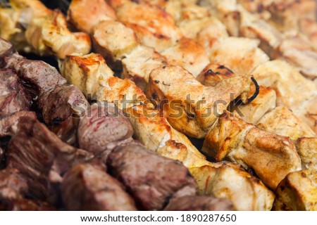 Background of chicken and lamb cut into pieces and fried on the grill. Fried kebab background with chicken and lamb.