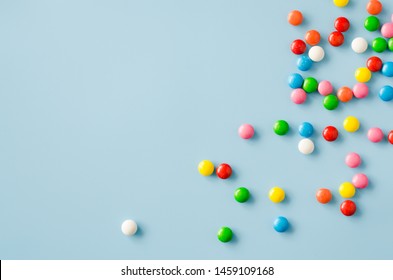 Background of chocolate candy with colored glaze. Scattered multicolored candy. Toned image