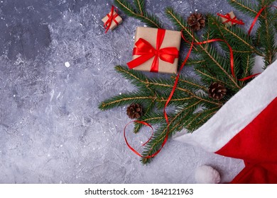 Background For A Christmas Card. Gifts And Fir Branches In A Santa Hat. Flat Lay, Copy Space