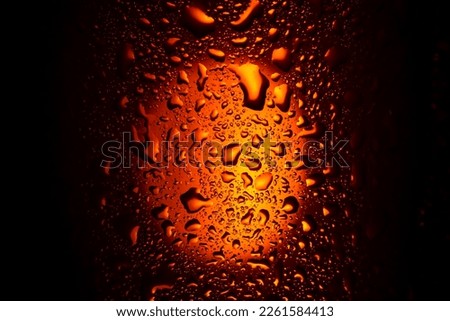 background. close up. drops on a glass with an orange drink. beer, tea