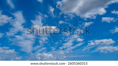 Background with clouds on blue sky. Sky view. Beautiful sunny sky. Clouds on blue sky. Sun shining through the puffy clouds.