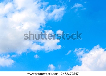 Background with clouds on blue sky. Sky view. Beautiful sunny sky. Clouds on blue sky. Sun shining through the puffy clouds. Airplane in the clouds.