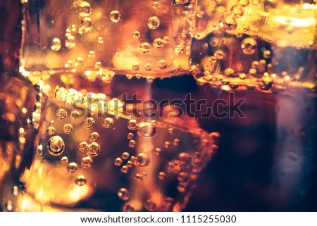 Background of cola with ice and bubbles. Side view background of refreshing cola flavored soda with bubbles with vintage tone.
