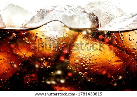 Background of cold cola with ice and bubbles.