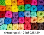 Background of colorful balls of wool threads for knitting, vibrant colors pattern, material for handmade items, hand knitting and needlework