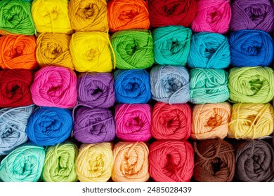 Background of colorful balls of wool threads for knitting, vibrant colors pattern, material for handmade items, hand knitting and needlework