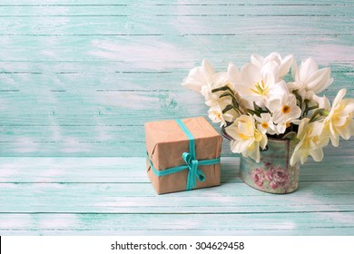 Background with colorful narcissus flowers and box with present  on turquoise painted wooden planks. Selective focus. Place for text.
 - Powered by Shutterstock