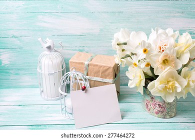 Background with colorful narcissus flowers , candles, box with present  and empty tag for text on turquoise painted wooden planks. Selective focus. Place for text. - Powered by Shutterstock