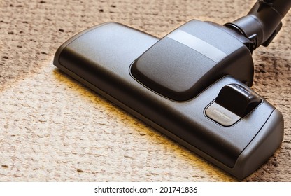 background with copy space. closeup cleaning with black vacuum cleaner hoover dirty, dusty floor beige carpet. housework.