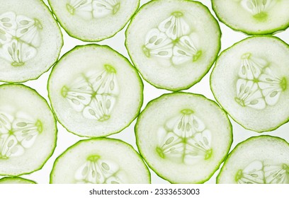 background of cut round slices of cucumbers, top view