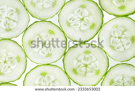 background of cut round slices of cucumbers, top view