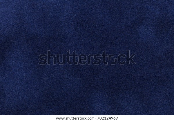 Background of dark blue suede fabric\
closeup. Velvet matt texture of navy blue nubuck\
textile.