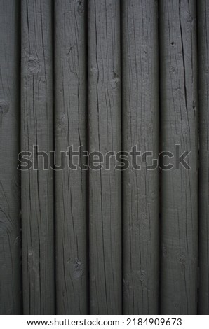 Background of a dark green fence made of wood poles