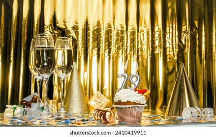 Background date of birth with number 79. Scenery festive glasses of champagne, anniversary in golden color. Copy space. Happy birthday postcard.