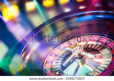 Background with detail of moving casino roulette with colored lights in gaming room.