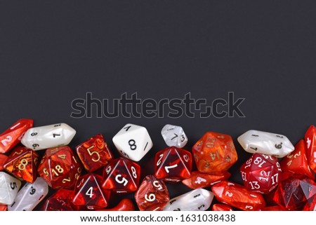 Background with different roleplaying RPG dice at bottom of dark black background with blank copy space