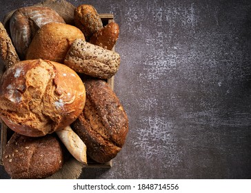 Background with Different Types of Bread put in a wooden box on dark surface. Close up. Bakery concept. Empty space for text. - Powered by Shutterstock