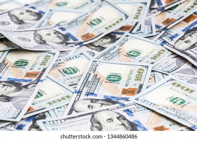 Background from dollars. Notes of one hundred American dollars are scattered across the background.
