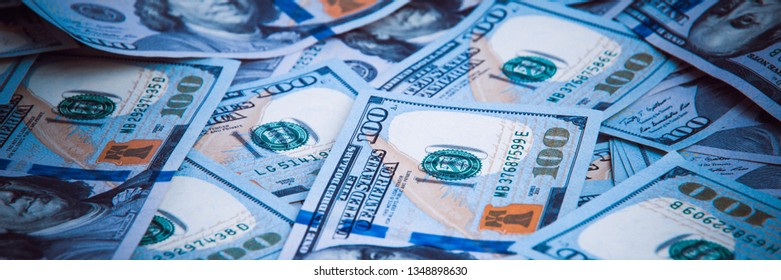 Background from dollars. Notes of one hundred American dollars are scattered across the background.