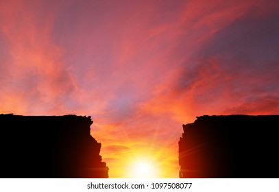 Background of dramatic sunset or sunrise in between two cliff silhouette. Nature landscape with copy space.