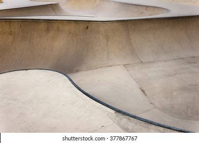 Background Of An Empty Bowl With Rails In A Concrete Skate Park.