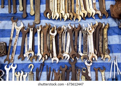 Background Equipment technician hardware wrench lots of old full rusty put on the stall reduced roadside stand on canvas blue.
