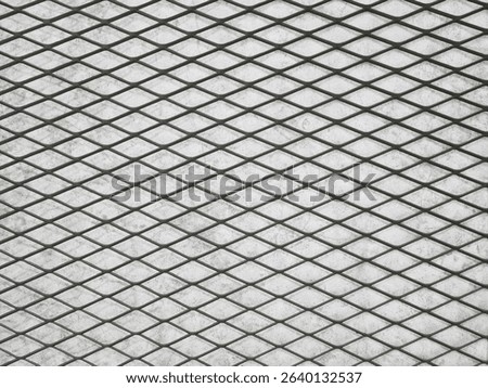 Background of expanded metal in a mesh pattern against a textured cement wall. Seamless diamond-shaped expanded metal pattern that repeats for use in construction, architecture and industry needs.