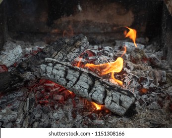 Background Of Fireplace With Gloving Embers. Close Up View On Smouldering Fire. Embers Burning With Red And Yellow Flame. Texture Of Ash And Glowing Embers. Blurred Background. Soft Selective Focus