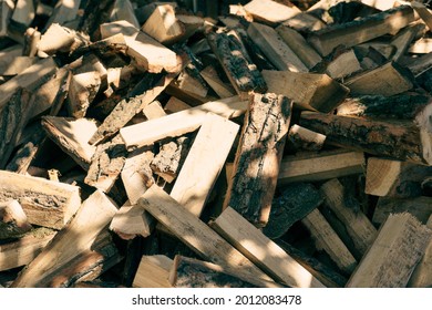 The background of the firewood is chopped firewood on a stack. Dry logs of firewood in a heap.