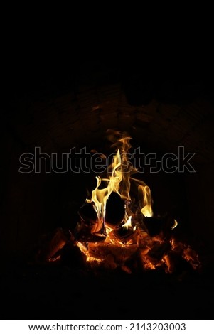 Background of the flame in the oven. Tongues of fire in brick fireplace. Fire texture.