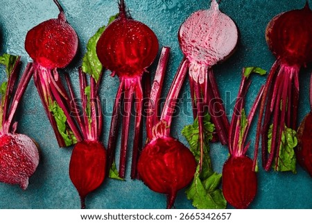 Background of fresh young beets with stems. Sliced beets on a stone background. Top view.