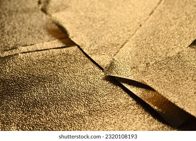 Background of gold textured foil sheets. Pieces of gold foil. - Shutterstock ID 2320108193
