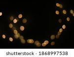 Background of golden, yellow bokeh (led strip light in a 50mm lens) on a dark black background.  Design elements for Merry Christmas and New Year background