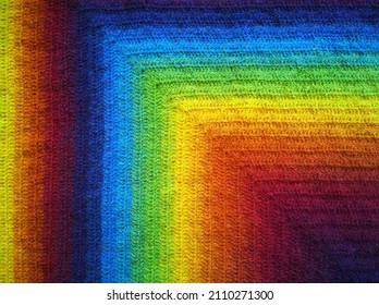 Background from gradient rainbow bright color: dark red  orange  yellow  green  blue  violet  blueberry  Beauty geometry  Colorful knitwear  Crocheted wool fabric  DIY  Knitting cozy blanket 