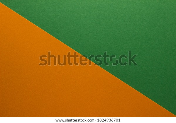 Background of green and orange paper divided\
diagonally. Sheets of blank orange and green paper with fine\
texture, close up.