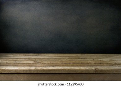 Background With Grunge Black Wall And Wooden Table Deck.