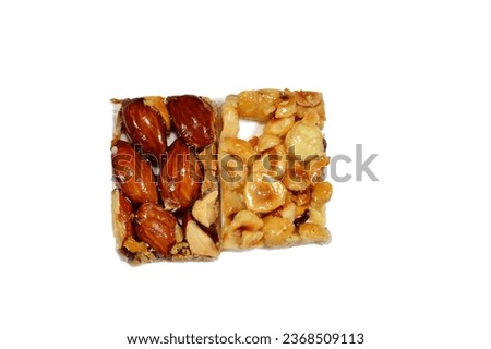 Background of Hazelnuts and roasted almonds on top of Arabic sweet delicious Noga, Egyptian cultural desserts of prophet Muhammad birth celebration (mawlid halawa), festive Arabian candy and sweets