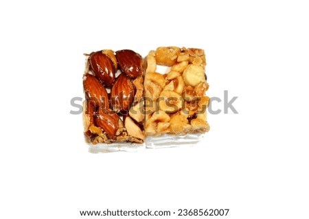 Background of Hazelnuts and roasted almonds on top of Arabic sweet delicious Noga, Egyptian cultural desserts of prophet Muhammad birth celebration (mawlid halawa), festive Arabian candy and sweets