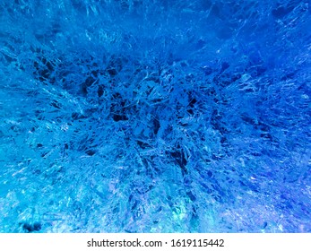background of ice with a pattern of cracks and blue backlight - Shutterstock ID 1619115442