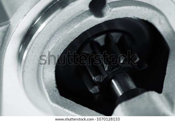 Background image of auto parts\
with rotor close-up. Big black pinion in metal part. Gear parts\
inside.