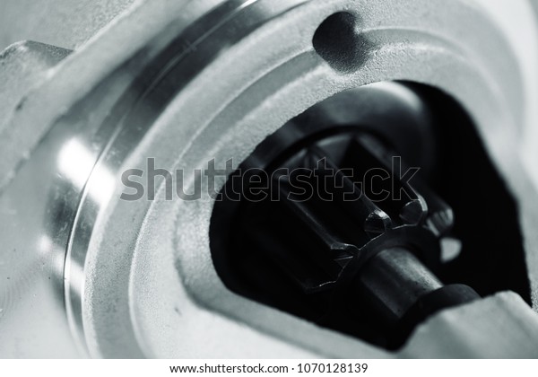 Background image of auto parts
with rotor close-up. Big black pinion in metal part. Gear parts
inside.