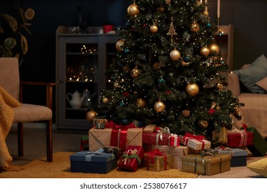 Background image of beautiful Christmas tree with gold accents and pile of presents in cozy home interior in low lighting copy space