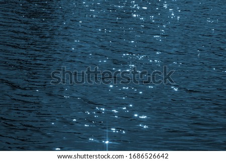 Background image - blue water with a reflection of the sun.