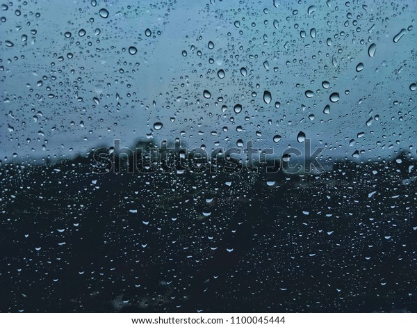 Background image\
blurred, rain on the car\
mirror.