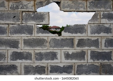 The Background Image Of A Brick Wall Blocked By A Car Crash Damaged Through A Hole.  Can See Other People's Homes Far Away