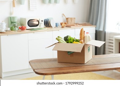 Background image of cardboard box with food on wooden table in minimal kitchen interior, copy space - Powered by Shutterstock