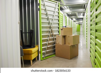 Background Image Of Cardboard Boxes Stacked By Open Door Of Self Storage Unit, Copy Space