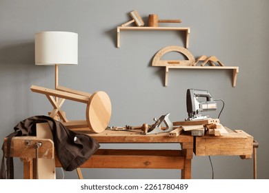 Background image of carpenters workstation, carpenters work table with different tools, wood cutting, a jigsaw, a cipher machine, and a chair made in a carpentry workshop.