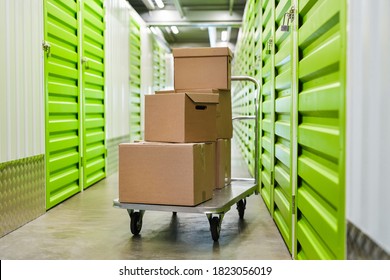 Background image of cart with cardboard boxes in empty hall of self storage facility, copy space - Shutterstock ID 1823056019