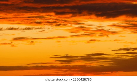 Background image with clouds in extreme colors of a sunset. The sky seems to burn. Photo from nature - Shutterstock ID 2260428785